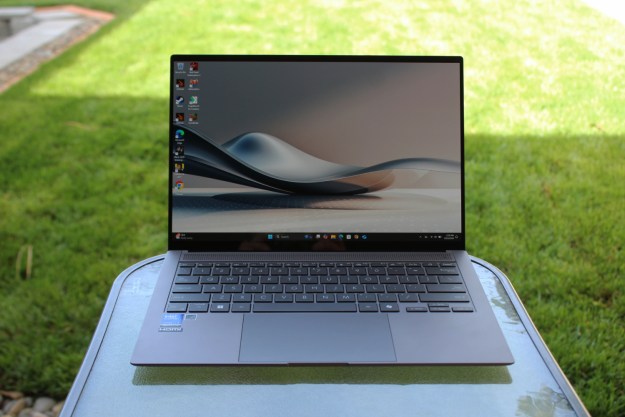 The Zenbook S 14 on a table in front of a grass lawn.