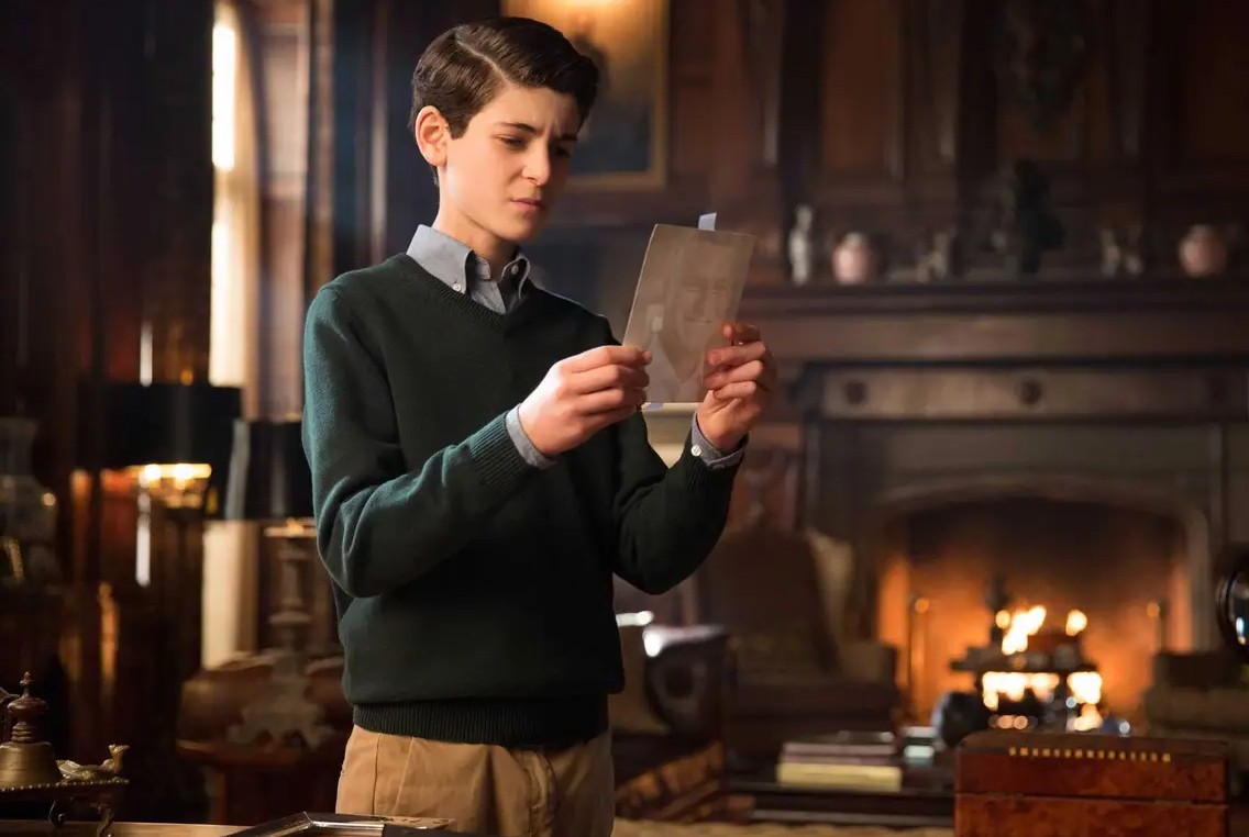 Bruce Wayne looks at a photo in Gotham.