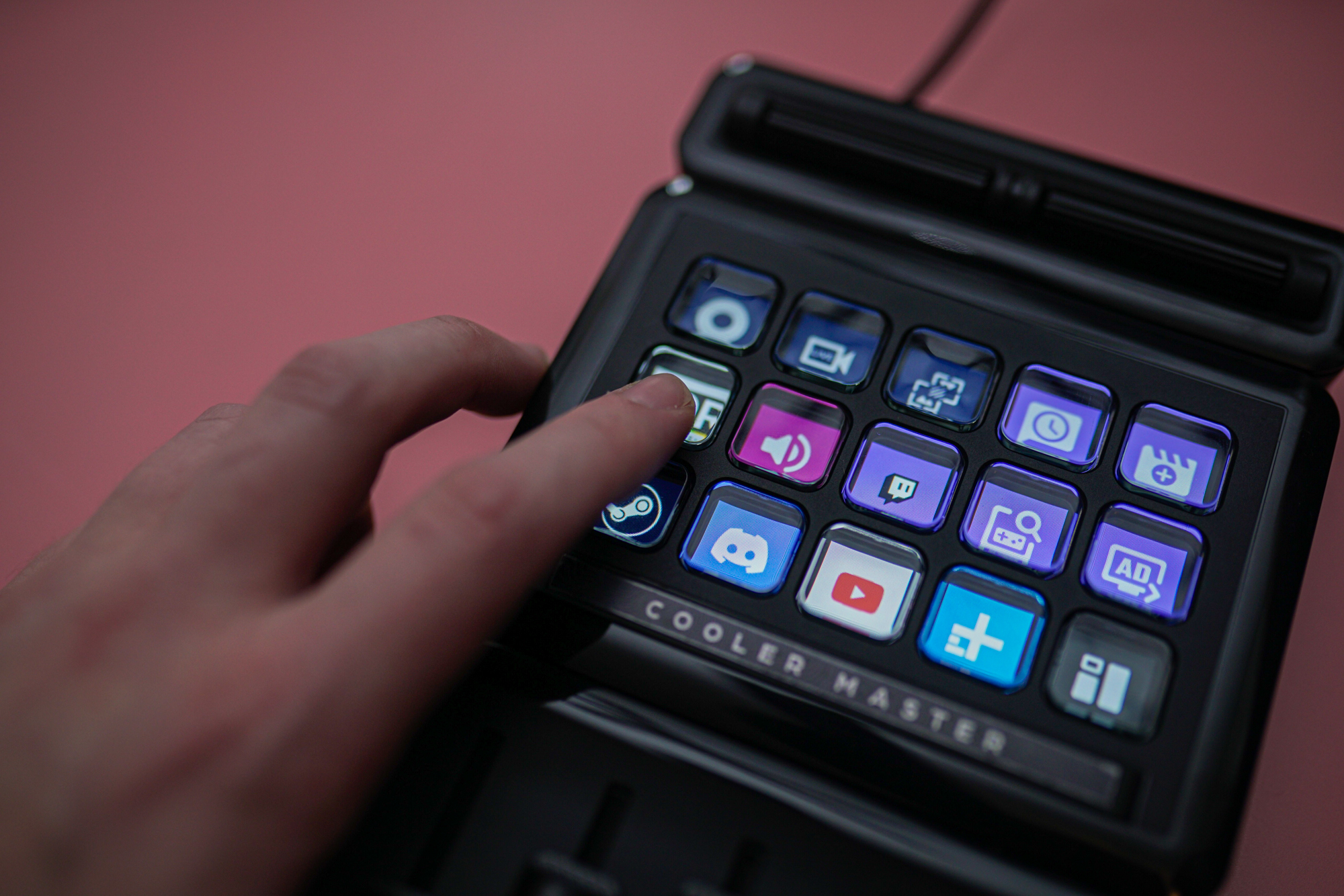 A hand pressing a button on the Cooler Master MasterHub.