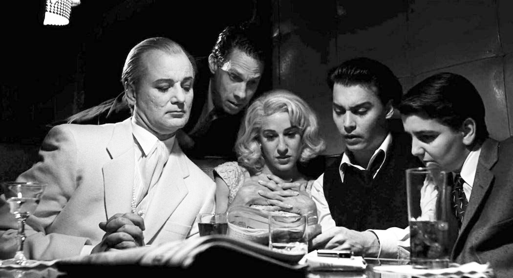 5 people look at a newspaper in Ed Wood.