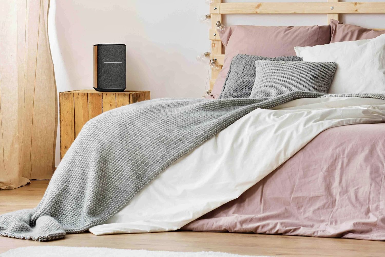 The Edifier MS50A Wi-Fi Smart Speaker on a table in a bedroom.