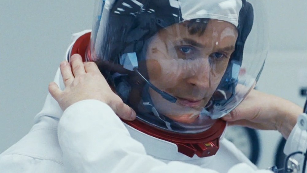 Um astronauta coloca seu capacete em First Man.