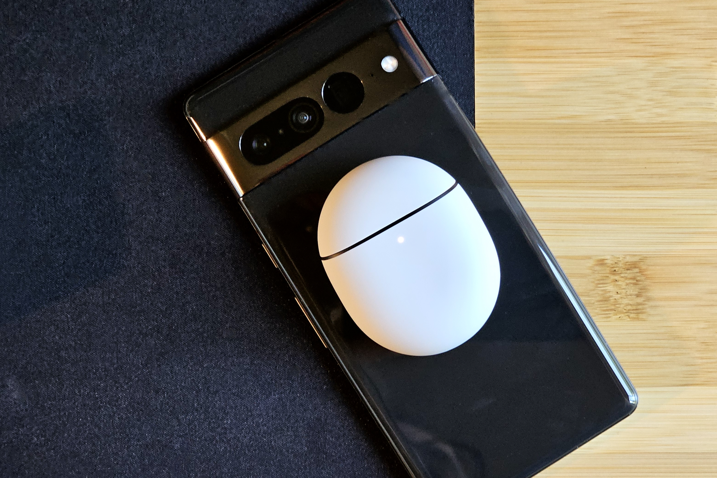 Google Pixel Buds Pro 2 carregando sem fio na parte traseira de um Google Pixel 7 Pro.