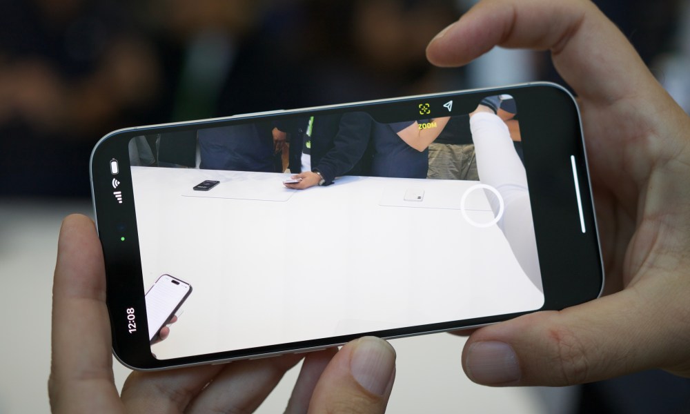 Someone using the Camera Control button on the iPhone 16.