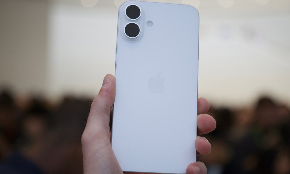 Someone holding the iPhone 16 in its white color.