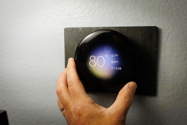 A hand turning the Nest Thermostat.