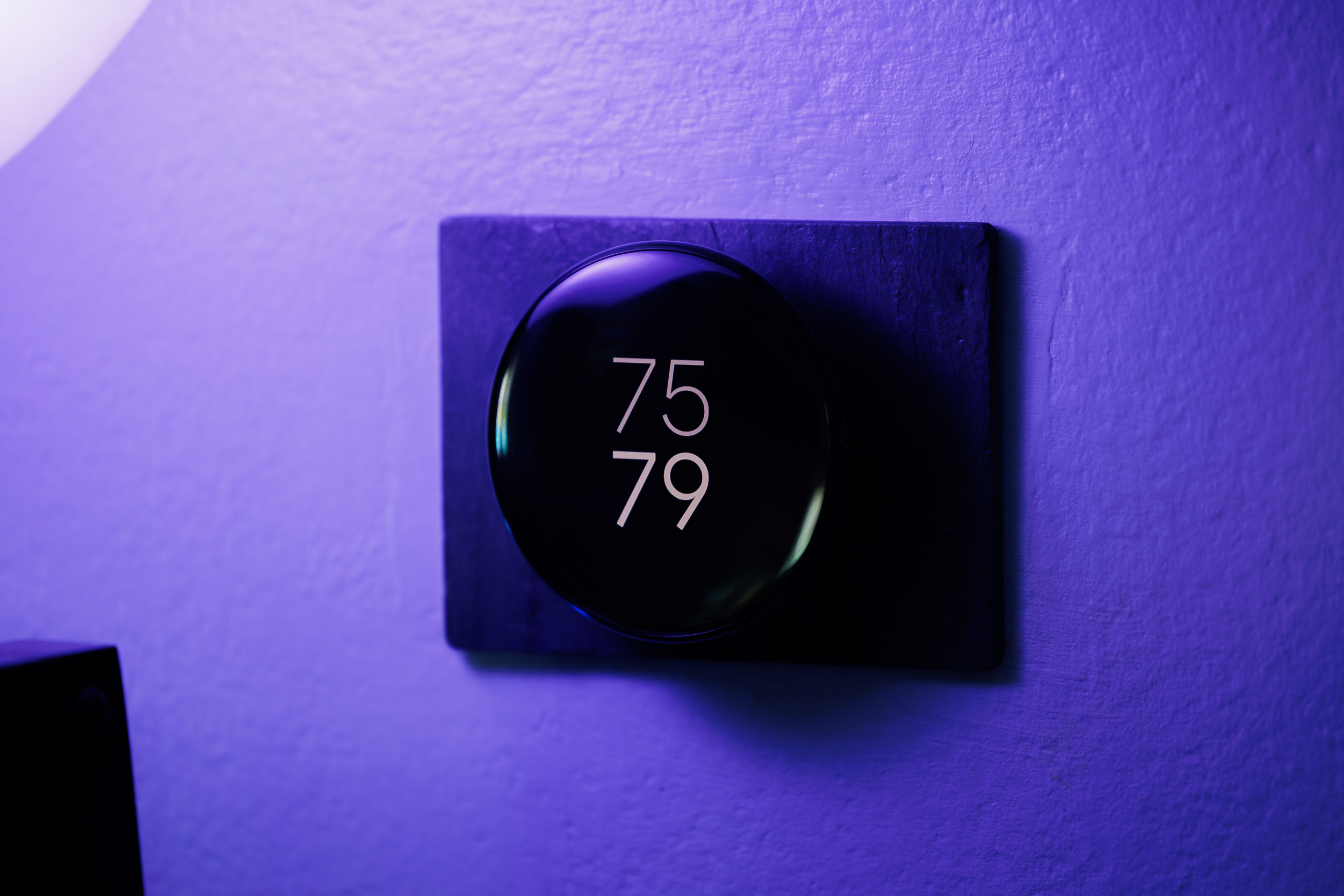 The fourth-generation Nest thermostat showing the current indoor temperature and the target temperature.