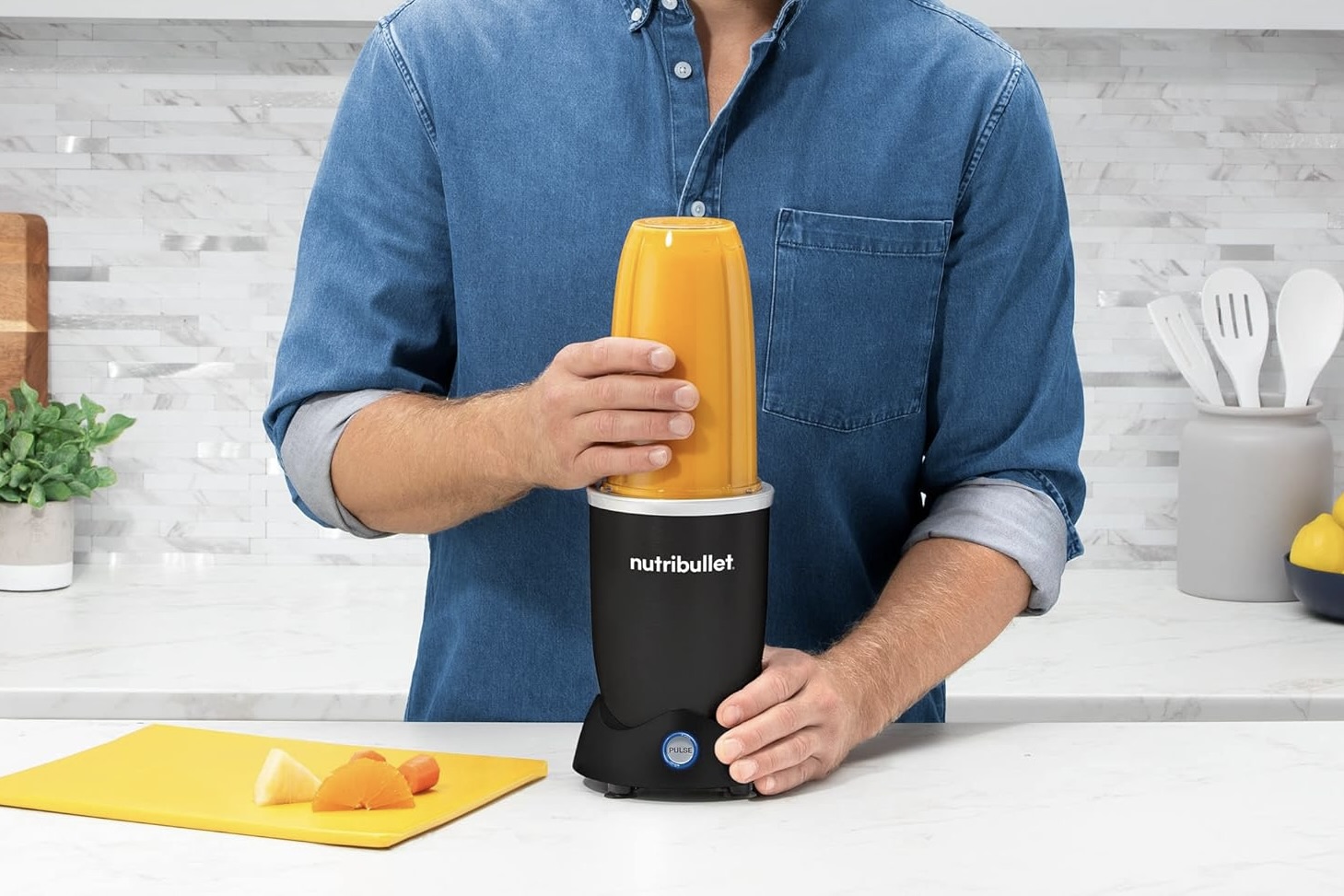 A person using the nutribullet Pro+ Personal Blender in a kitchen.