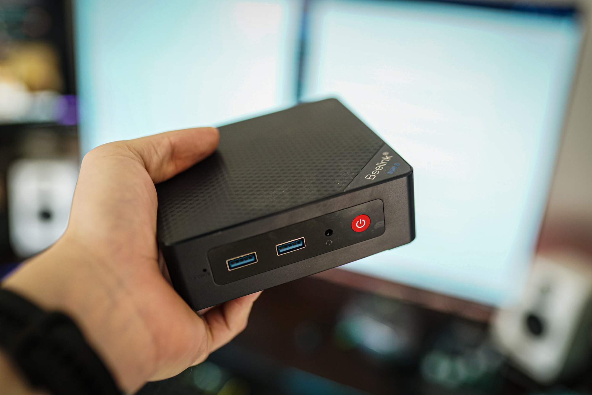 Une main tenant un mini PC Beelink.