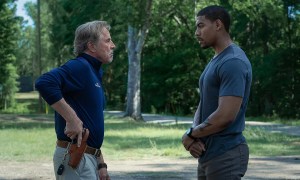 Don Johnson puts his hand on a gun while Aaron Pierre stands across from him.