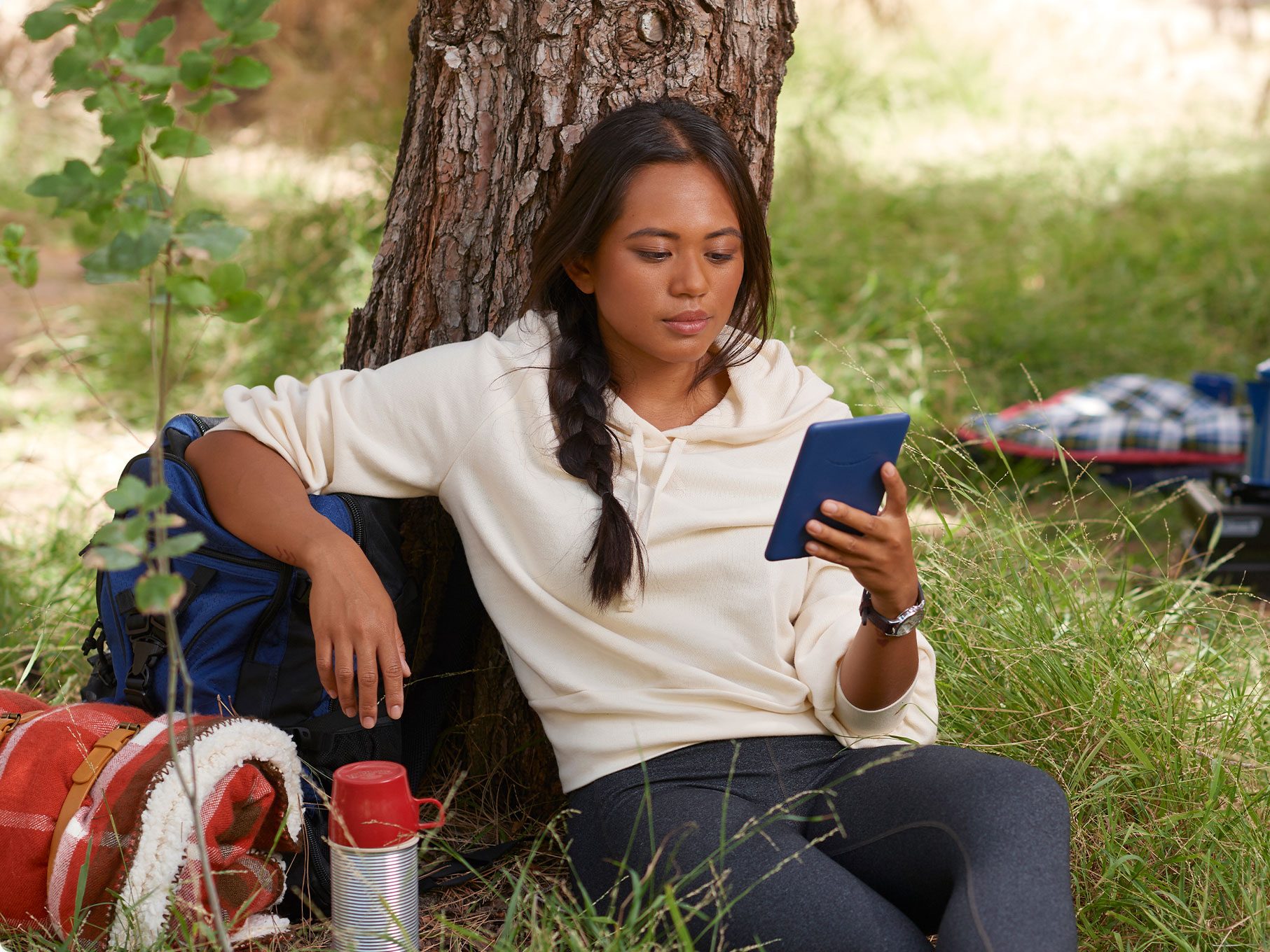 Une femme lit sur un Kindle d’Amazon standard.