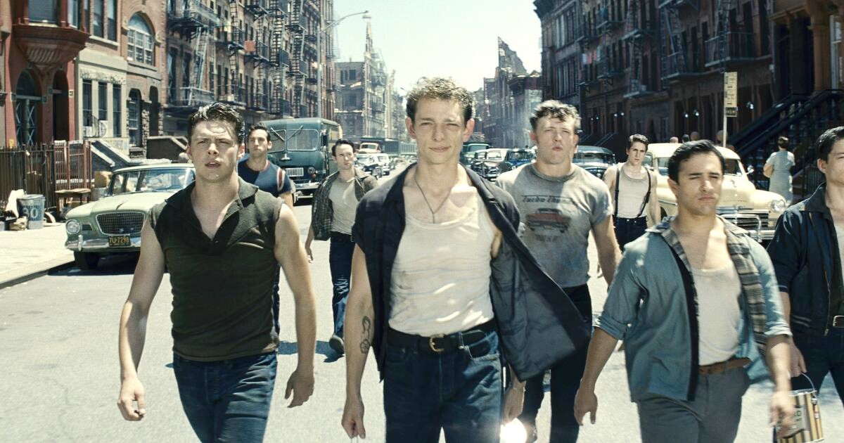 A gang of males walks down a street in West Side Story.