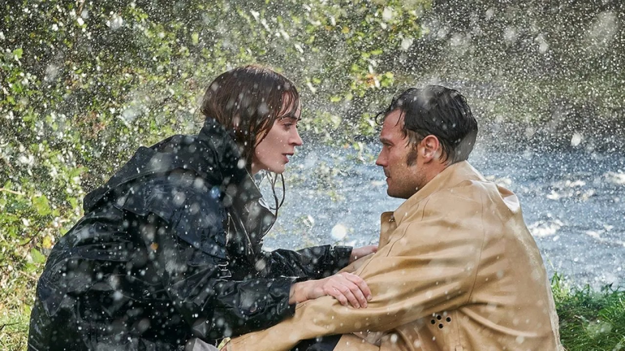 A man and woman squat in the rain in Wild Mountain Thyme.