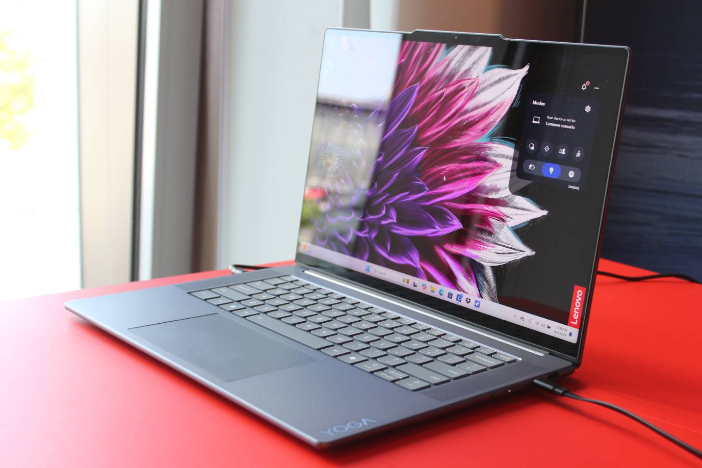 A Yoga Slim 7i on a red table.