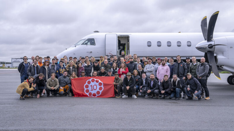 A equipe da 10 Chambers do lado de fora de um avião.