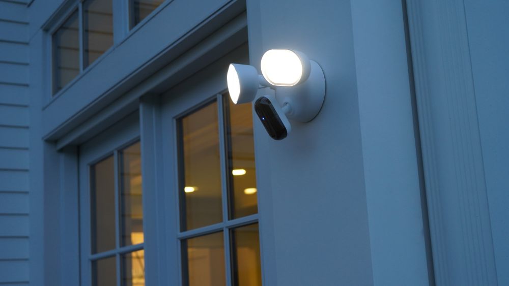 Arlo Wired Floodlight camera installed near a door.