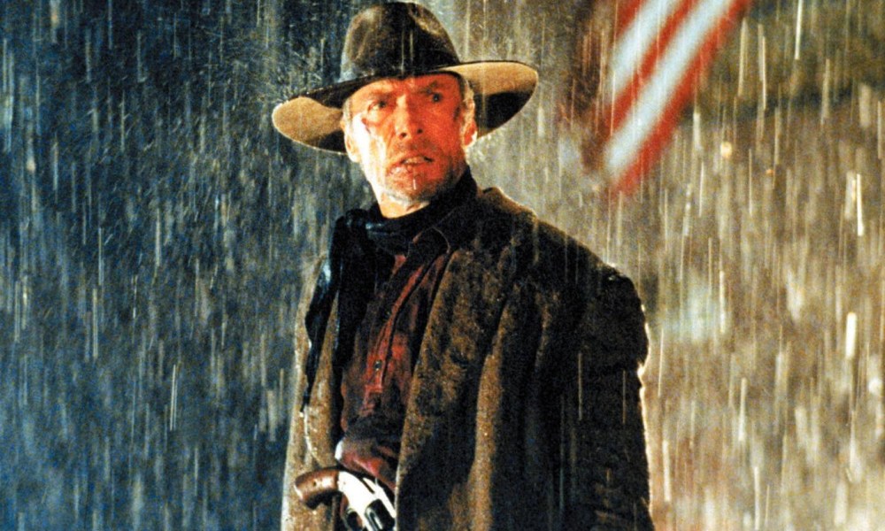 Clint Eastwood stands in the rain in Unforgiven.