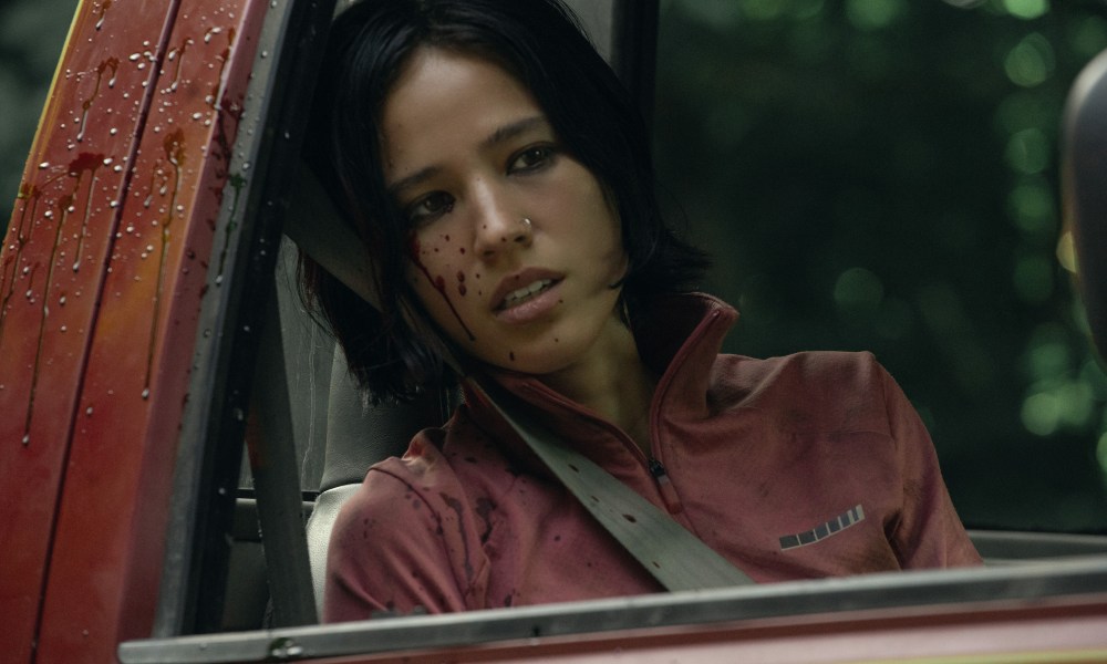 A woman puts her head up against the window in a truck.