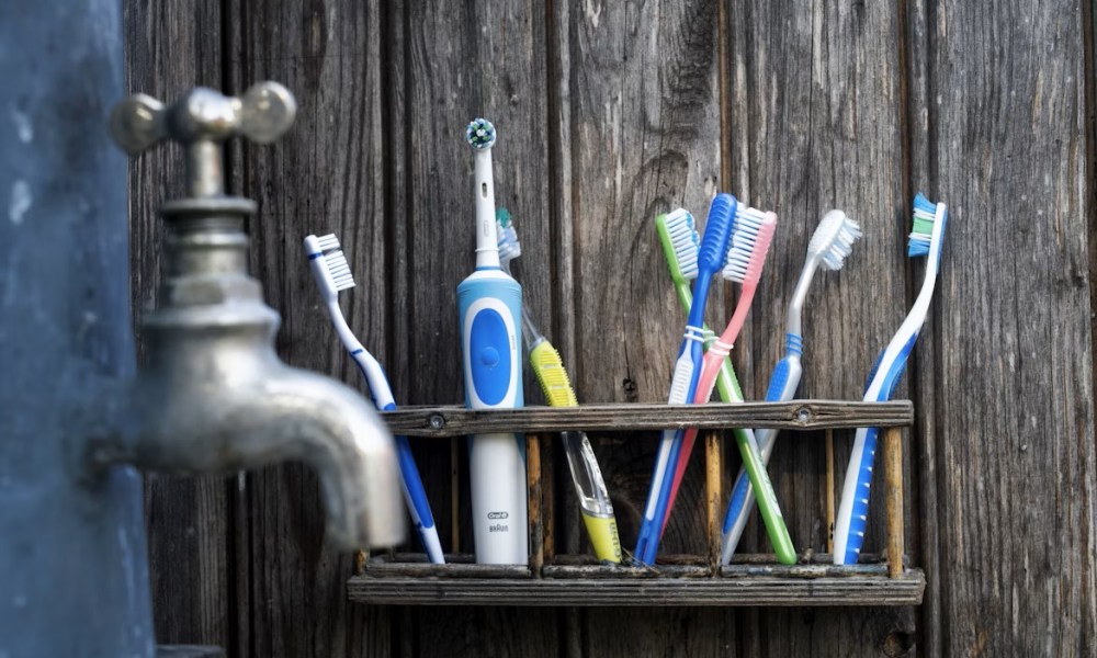 Electric Toothbrush with regular brushes on the shelf -- Henrik Lagercrantz Unsplash