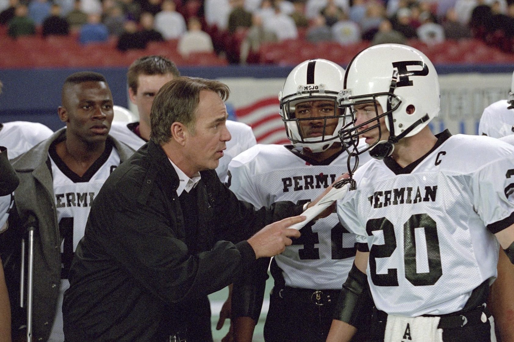 A coach points his papers at a player and points.