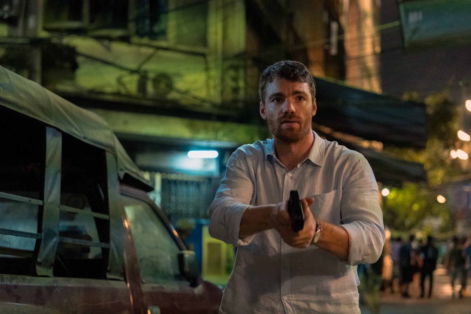 Gabriel Basso points a gun down.