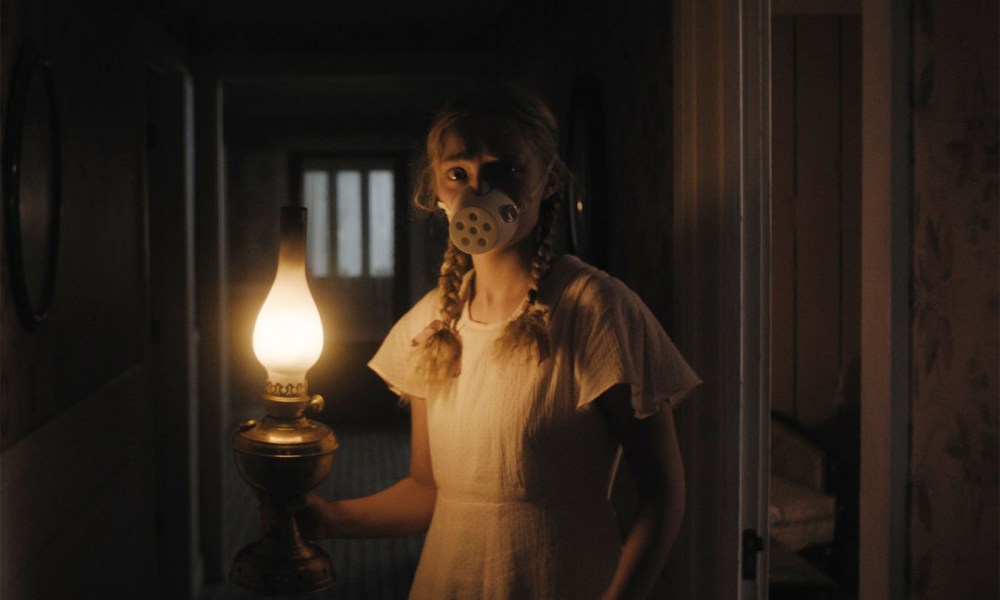 A young girl holds a lantern in a tense scene from Hold Your Breath.