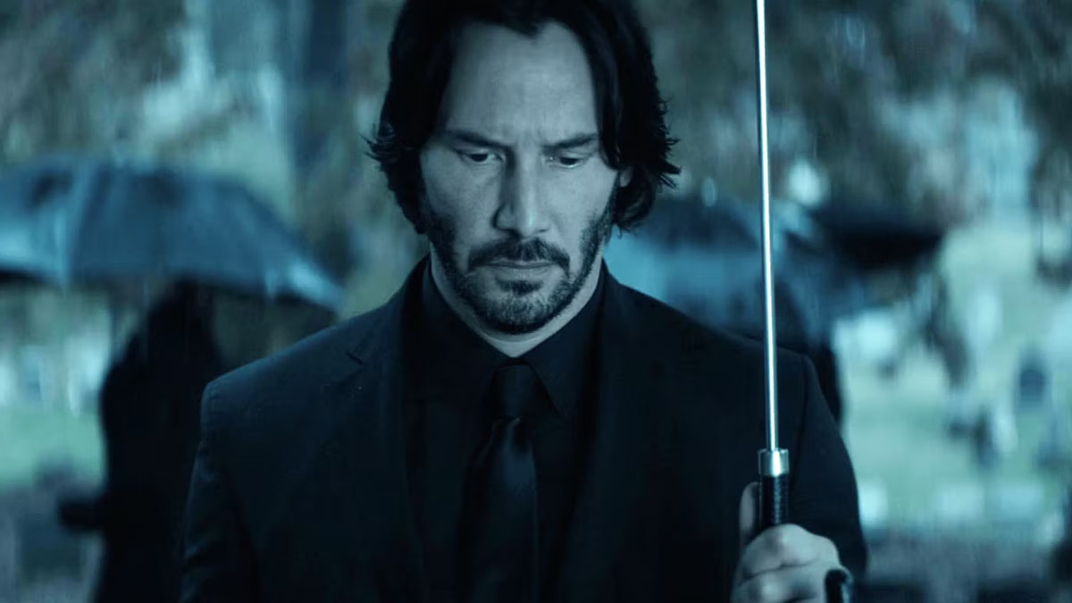 Keanu Reeves sostiene un paraguas en John Wick.