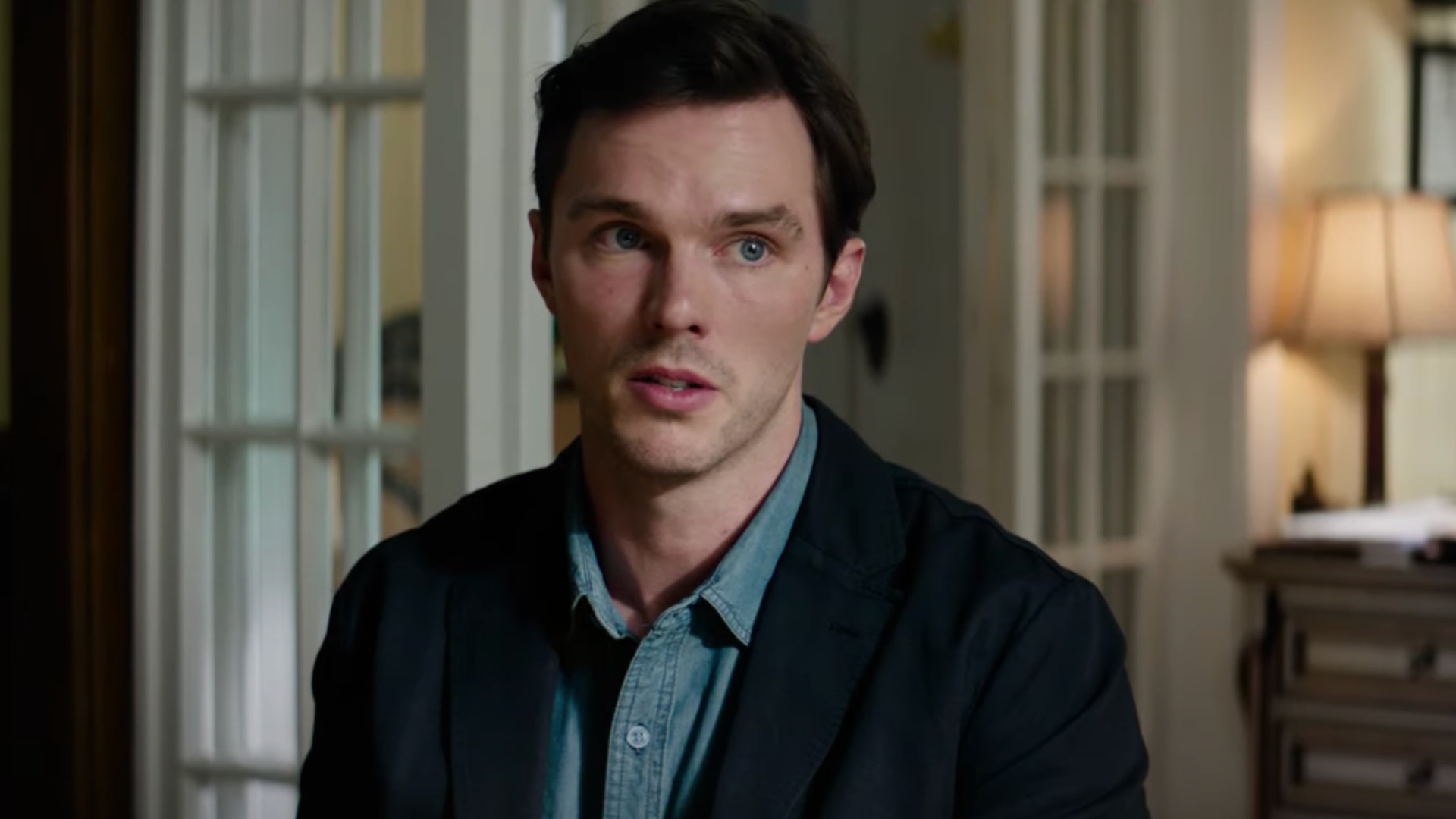 Nicholas Hoult setzt sich und sieht besorgt aus.