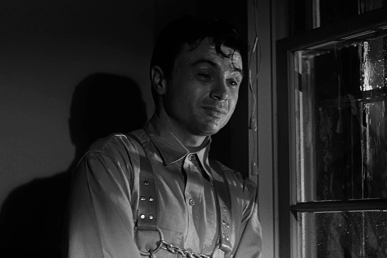 Robert Blake se tient près d’une fenêtre trempée par la pluie dans In Cold Blood.