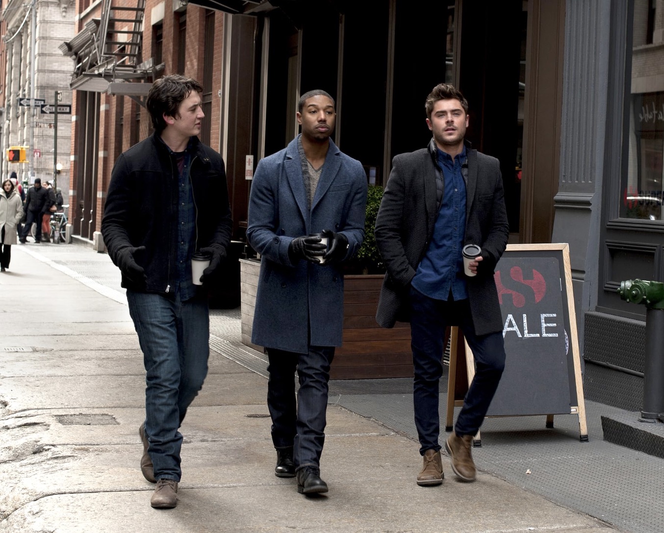 Trois hommes marchant dans la rue en hiver.