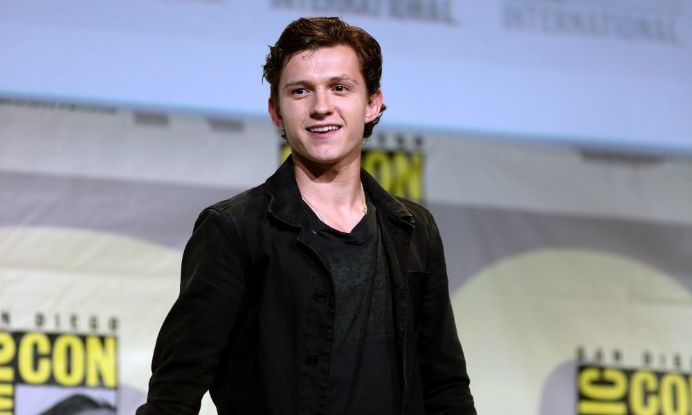 Tom Holland smiles and poses for a picture at Comic-con.