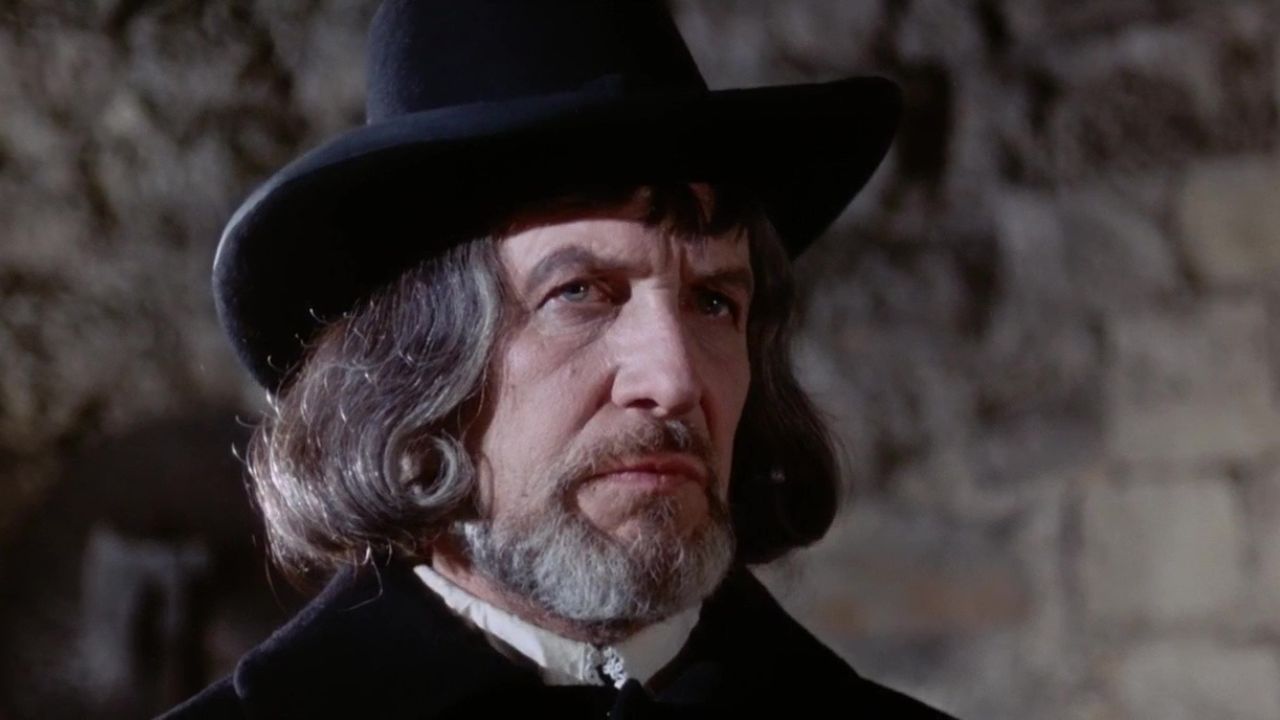 Vincent Price dans le rôle de Matthew Hopkins regardant attentivement quelque chose hors caméra dans Witchfinder General.