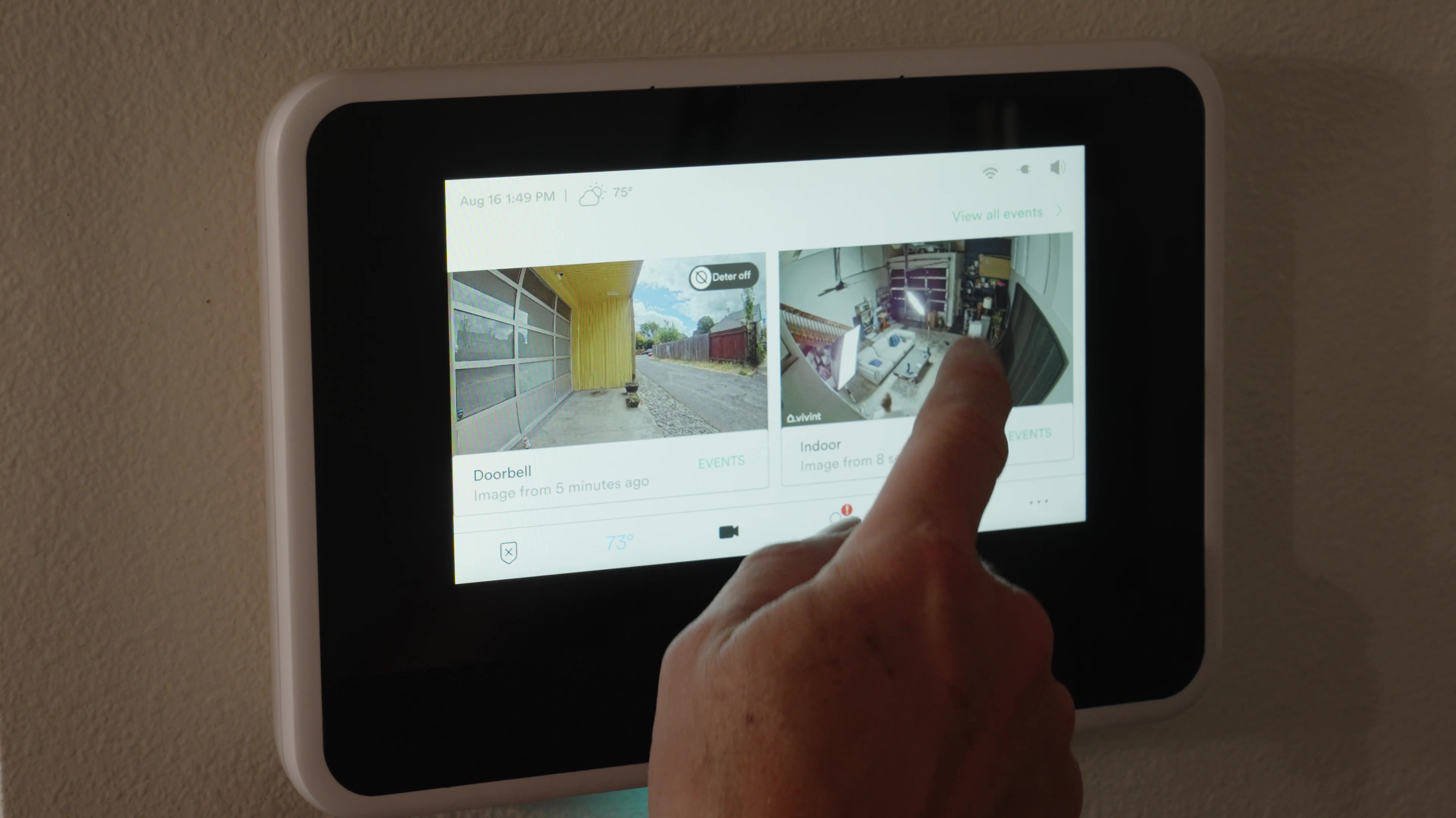O Vivint Smart Hub montado em uma parede com as visualizações da câmera na tela.