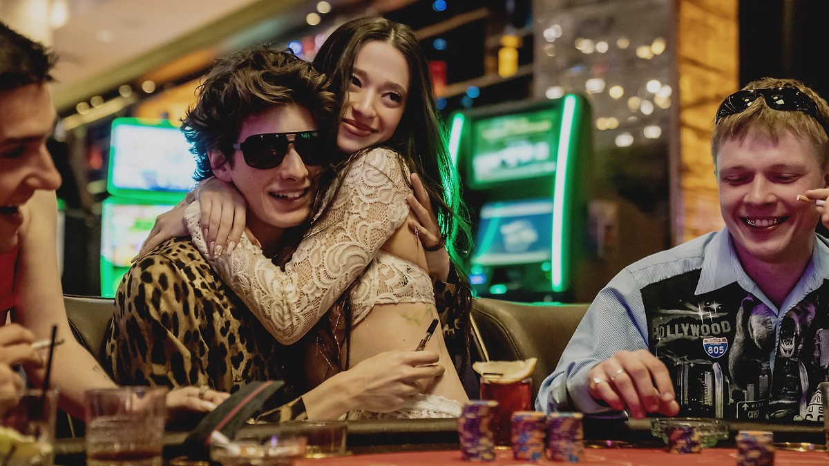 Une femme est assise sur un homme à une table de poker à Anora.