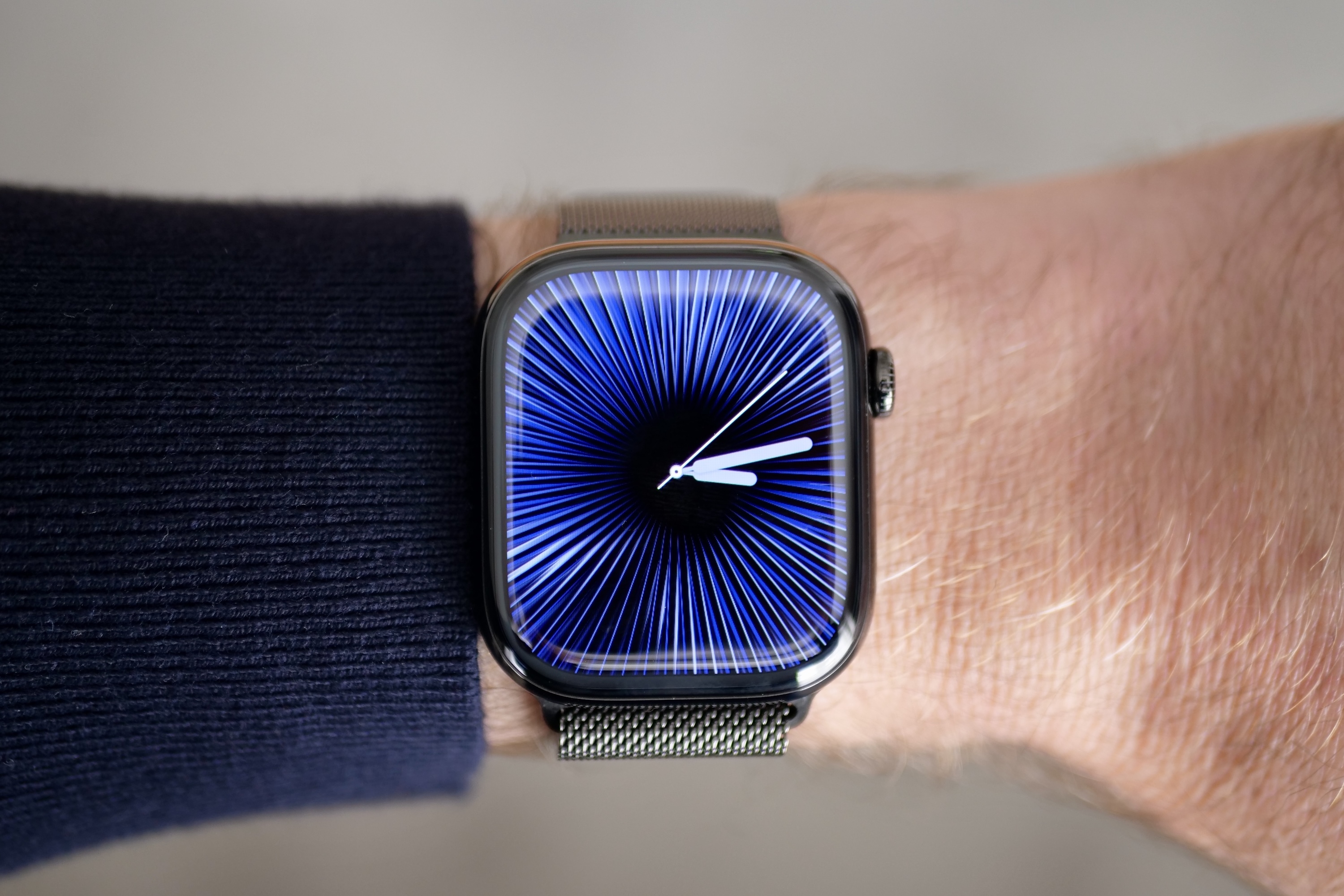 Una persona que lleva el Apple Watch Series 10 en titanio con la esfera Reflections.