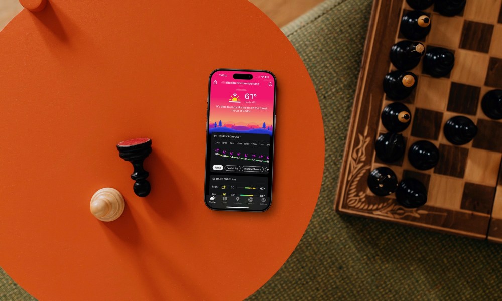 Carrot Weather app on iPhone on table next to chess board.