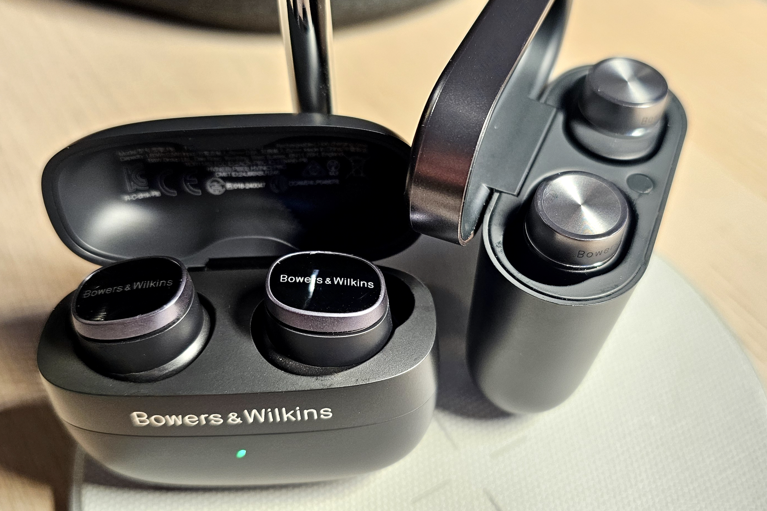 Bowers & Wilkins Pi8 এবং Pi7 S2 চার্জিং কেস ঢাকনা খোলা আছে।