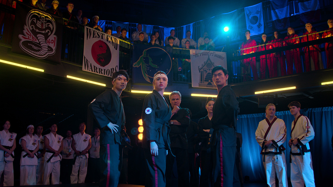 Several competitors from the Cobra Kai team watch the Sekai Taikai tournament.