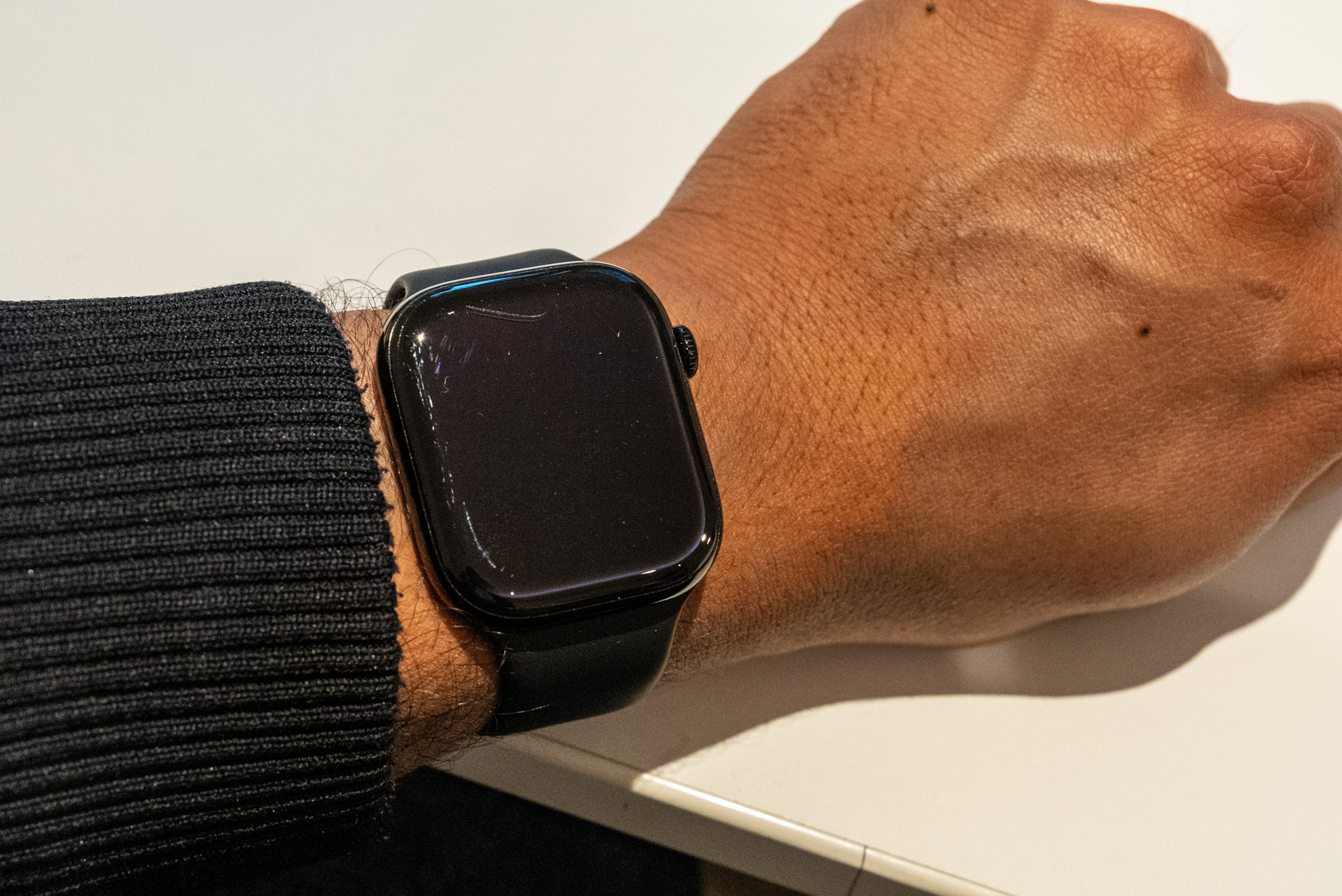 Apple Watch Series 10 danificado em um braço que está torcendo sobre uma mesa