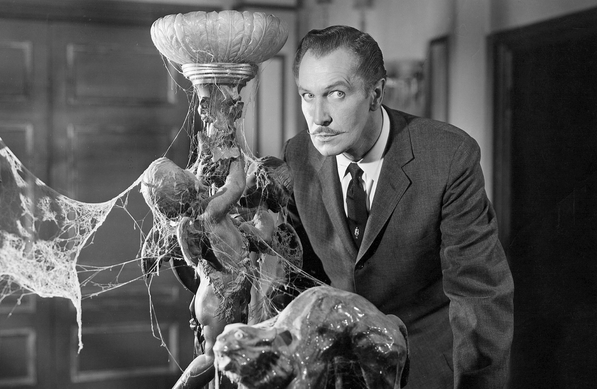 Vincent Price s'appuie sur une chaise dans House on Haunted Hill.