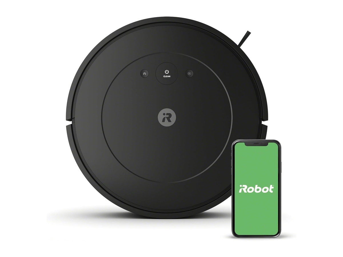 L'iRobot Roomba Essential à côté d'un smartphone sur fond blanc.