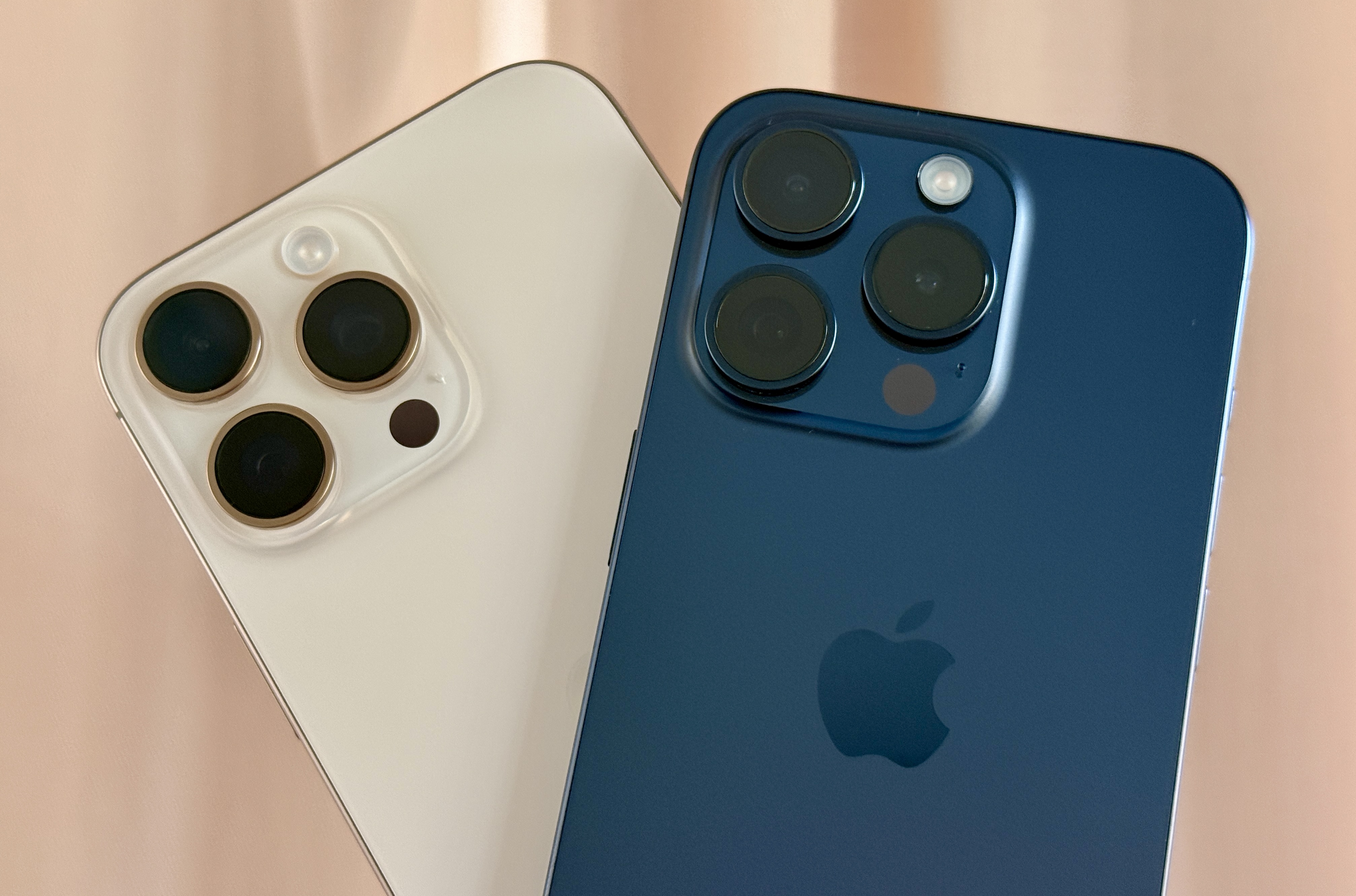 iPhone 16 Pro Max en titane naturel (à gauche) et un iPhone 15 Pro en titane bleu.