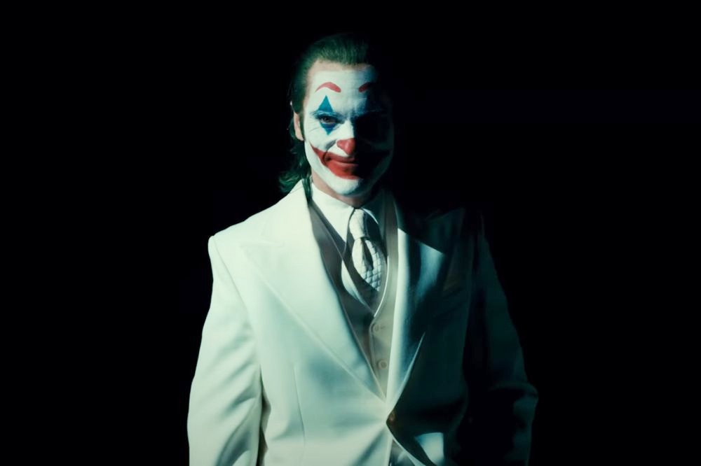 Un homme en costume blanc sourit dans Joker : Folie à Deux.