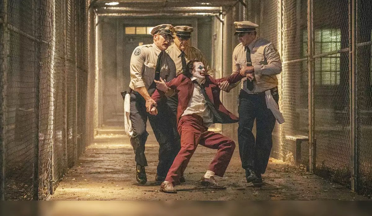 Трое охранников тащат Джокера в Joker: Folie a Deux.