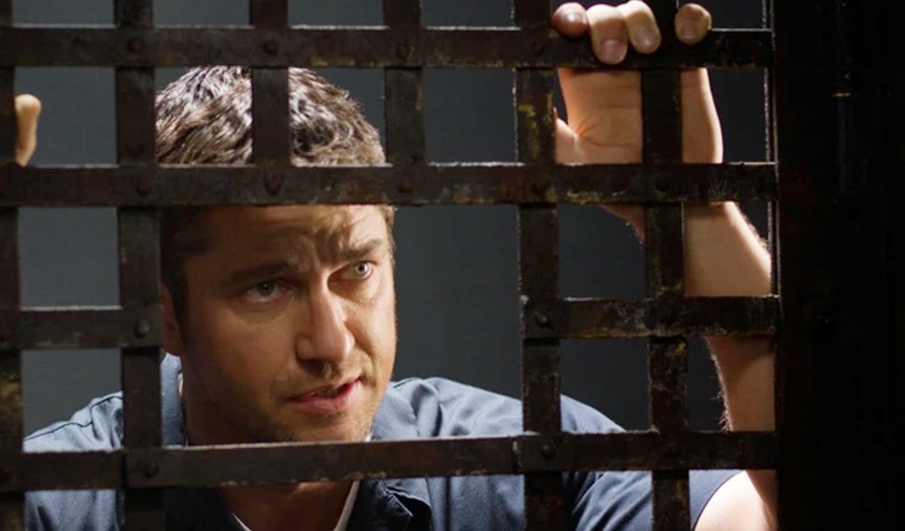 A man leans against his cell in Law Abiding Citizen.