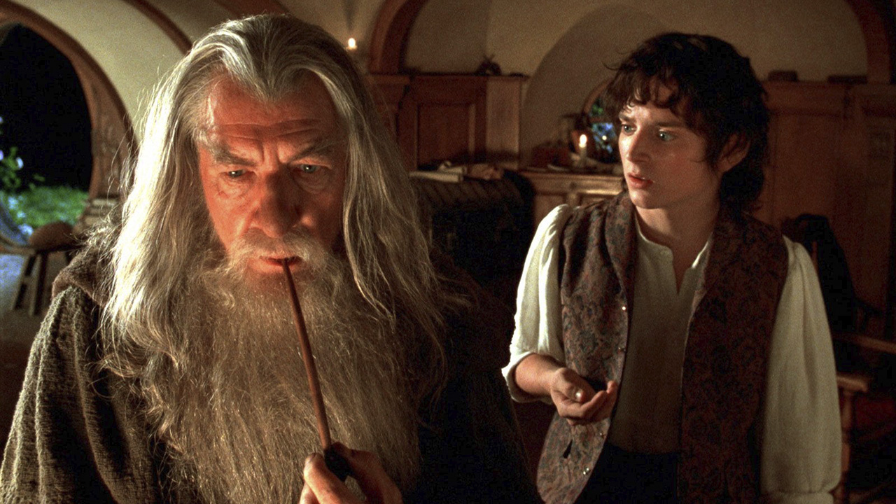 Gandalf in the foreground with Frodo behind him holding the ring in The Lord of the Rings: The Fellowship of the Ring.