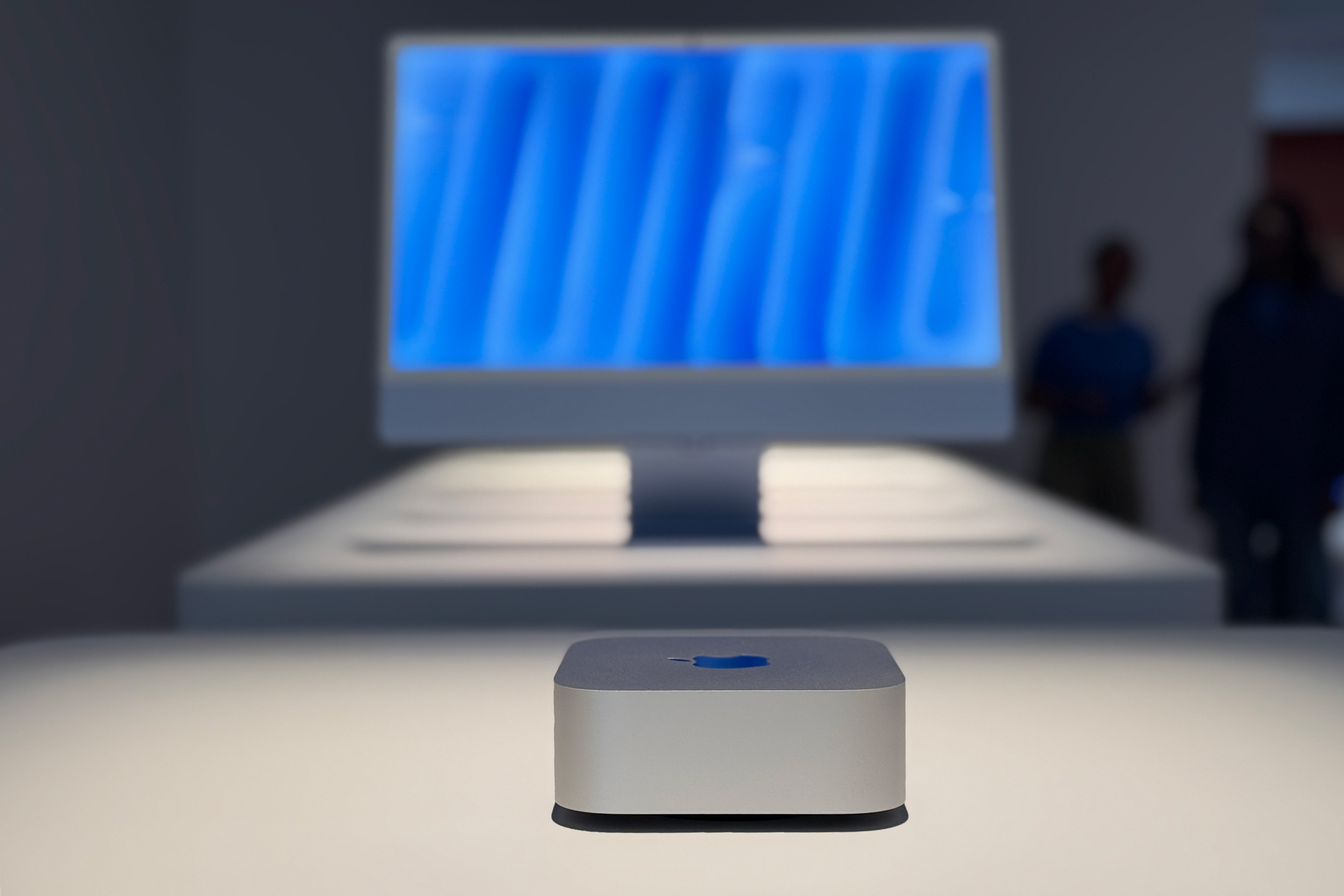 De M4 Mac mini met een display op de achtergrond.