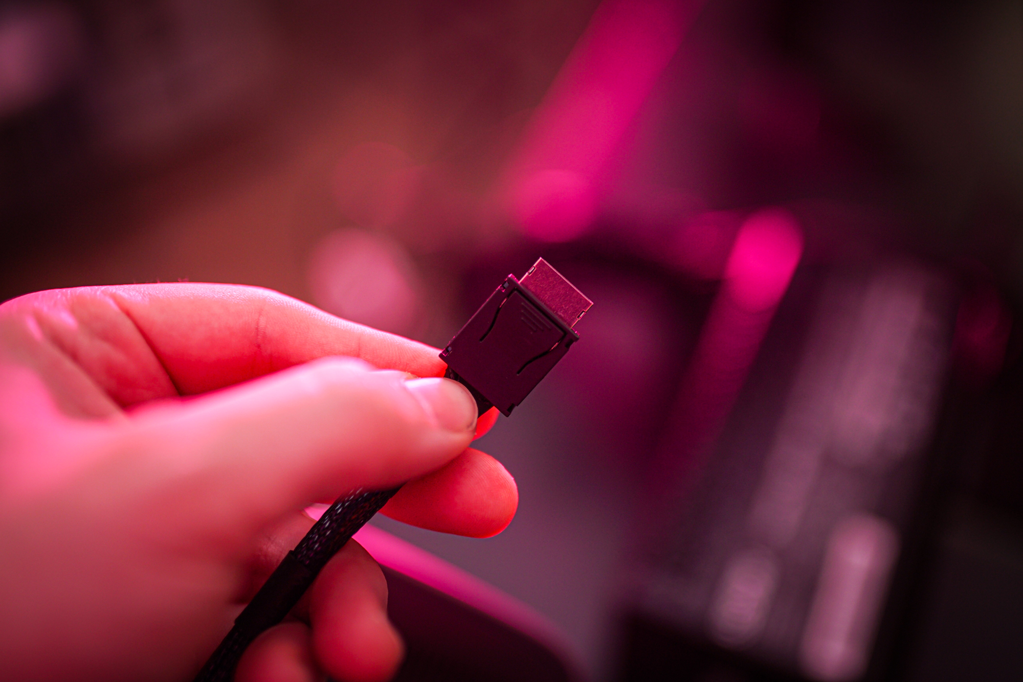 An Oculink cable held in someone's hand.