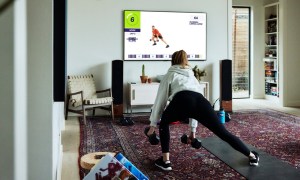 A woman works out with the F45 app on a Samsung TV.