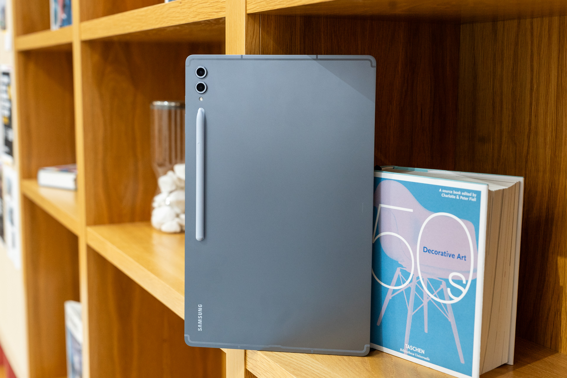 Samsung Galaxy Tab S10 Ultra on a bookshelf. 